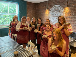 A group of women holding pottery up at a Cheeky Pottery Class in Brighton