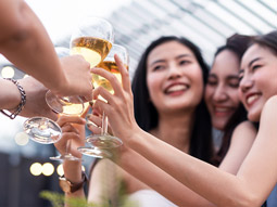 Three people having a drink on a rooftop terrace bar in Madrid