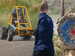 A split image of someone driving a dirt kart and someone throwing an axe at a wooden target