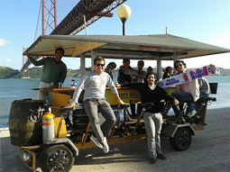 A group of men on a beer bike in front of a lake in Lisbon