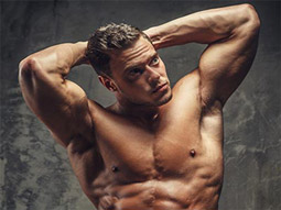 A topless man posing and flexing his muscles