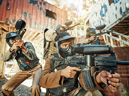 Two people paintballing wearing safety glasses and camo outfits in Lisbon