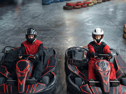 Two people in go karts about to race indoors in Bucharest