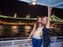 Two people on a party boat at night in Budapest