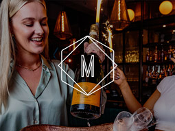 Manahatta logo overlaid on a bartender carrying prosecco