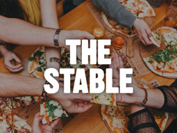 People helping themselves to pizza at Stable pizza 