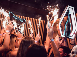 People with sparklers and bottles of alcohol at Akuarela in Valencia