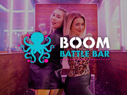 Two girls posing back to back at axe throwing at Boom Battle Bar