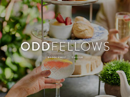 A glass of gin in front of an afternoon tea at Oddfellows in Chester
