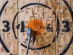 An axe in a wooden target at axe throwing in Split