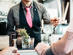 Someone using different ingredients to make a gin drink at a workshop