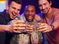 A group of men with glasses in hands, cheersing