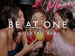 A photo of three girls drinking cocktails at Be at One