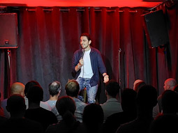 Someone performing a comedy show on stage at Comedy Club