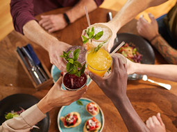 A group of people clinking their cocktails at bottomless brunch in Lisbon