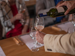 A glass of wine being poured at a wine tasting experience