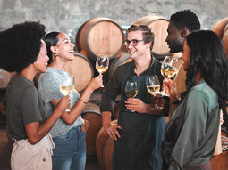 A group of people smiling and trying wines