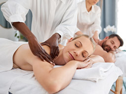 Two people receiving massages at a spa day