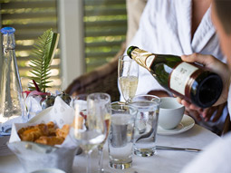 Someone pouring champagne into a glass at breakfast time