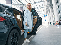 A girl stepping out of a transfer car at an airport