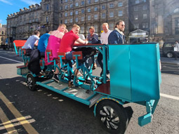 A group of men on a beer bike drinking beer around Newcastle