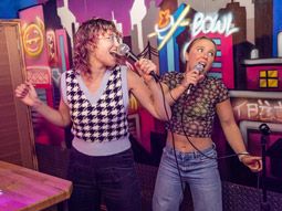 Two people singing karaoke at Roxy