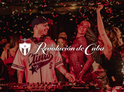 A DJ and some party goers partying underneath confetti with the Revolucion de Cuba logo over it 