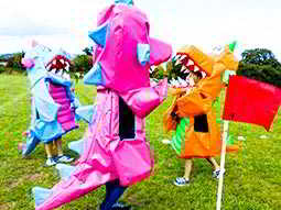 Three people dressed in purple, blue and orange dragon costumes