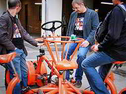 Three men sat on a conference bike