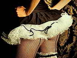 The back of a woman in fishnets and a black tutu dress