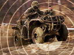 A faded image of a sniper target on an image of a man driving a quad bike