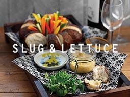 A waffle covered in fruit on a white plate with a fork