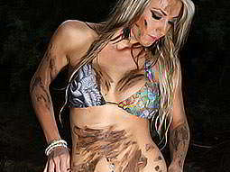 A woman in a bikini, covered in mud 