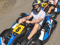 A man sitting in a go kart with a helmet on