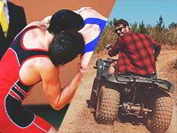 Two people wrestling in sumo suits in a field