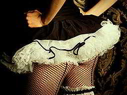 Close up on the back of a woman in a black and white tutu and fishnet tights
