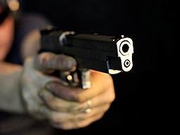 A pair of hands aiming a handgun past the camera