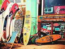 Some surfboards lined up outside a surf shop