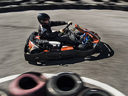Two people racing in go karts on an outdoor track