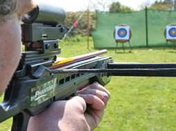 A man firing a cross bow at a target