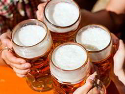 Four hands toasting with full beer steins