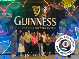 A man's hand holding a pint of Guinness