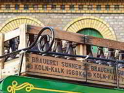 Wooden crates of beer stacked together with a brick wall in the background