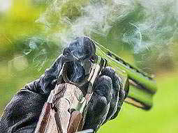An over/under double barreled shotgun cracked open and smoking