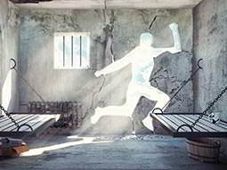 A stone prison cell with the outline of a person cut out of the wall