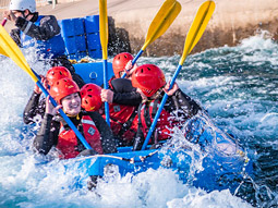 Bird's eye view of a stag group in a white water raft dinghy on a river
