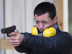 The silhouette of a person posing with a handgun