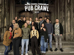 A tray of drinks being held by a man in a waistcoat