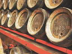 A stack of wooden barrels on a red shelf