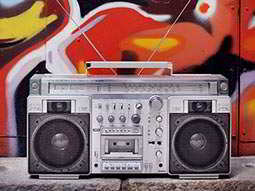 A silver boombox in front of a paint mural